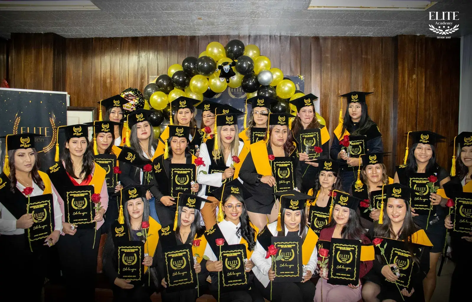 Promoción de graduadas de Elite Academy con togas y birretes