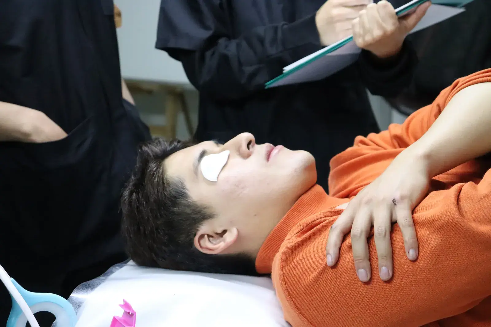 Modelo recibiendo un tratamiento de ojos en una clase práctica