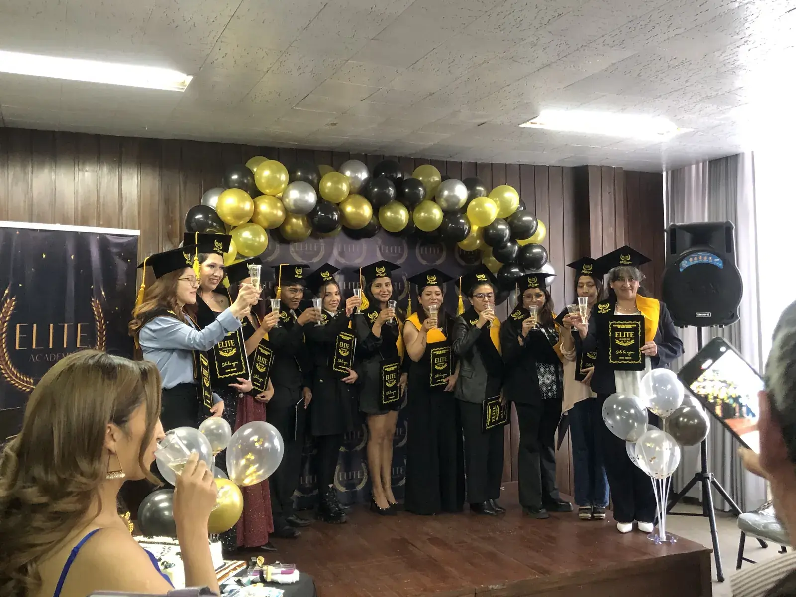Promoción celebrando entre globos dorados y negros